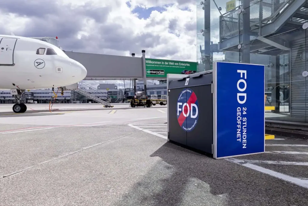 An FOD container placed at an apron area within an airport.